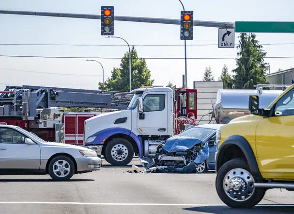 Intersection accident involving a car and a big rig semi truck with tank semi trailer